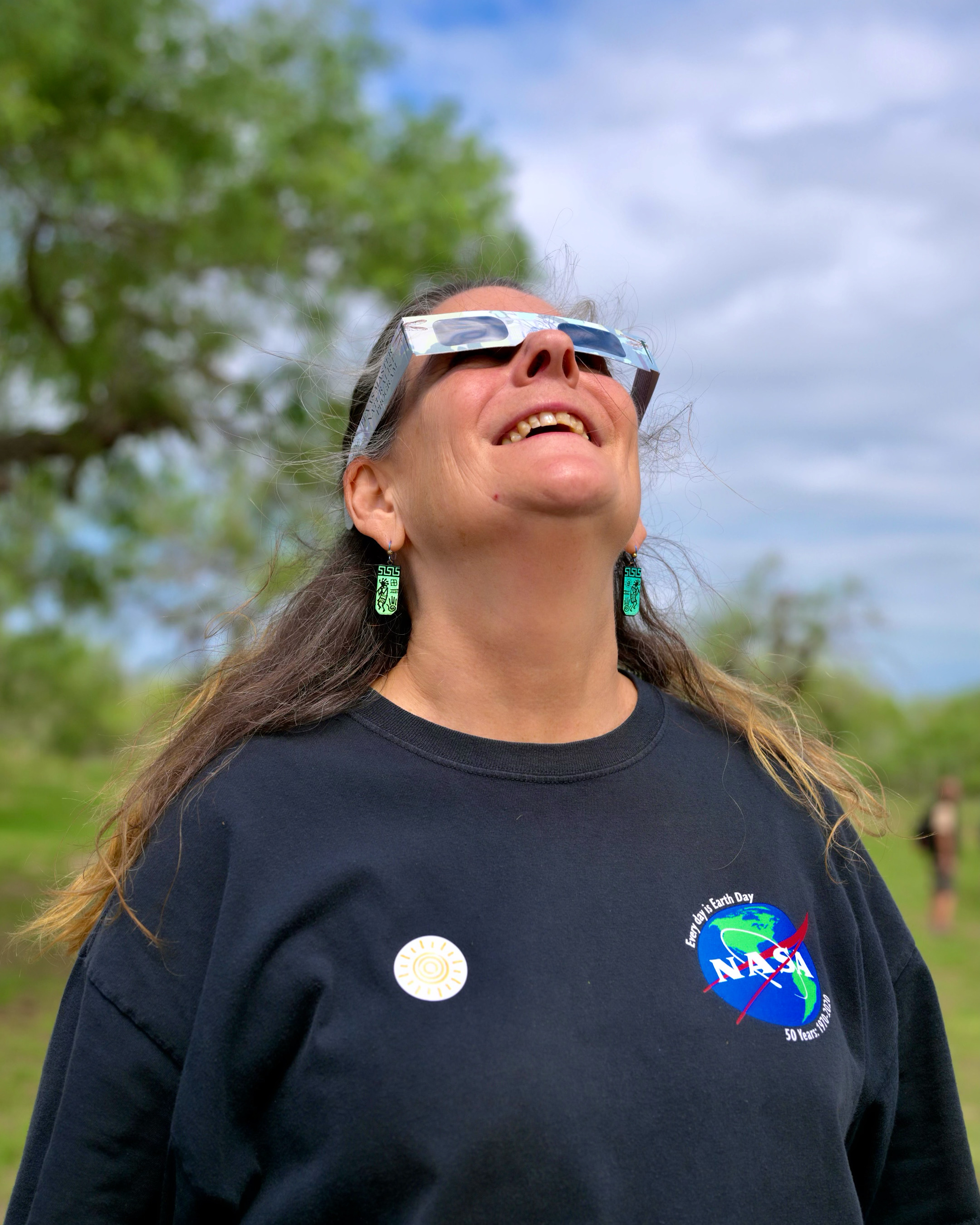 Dorian Janney looks to the sky while wearing eclipse glasses during the 14 October annular eclipse