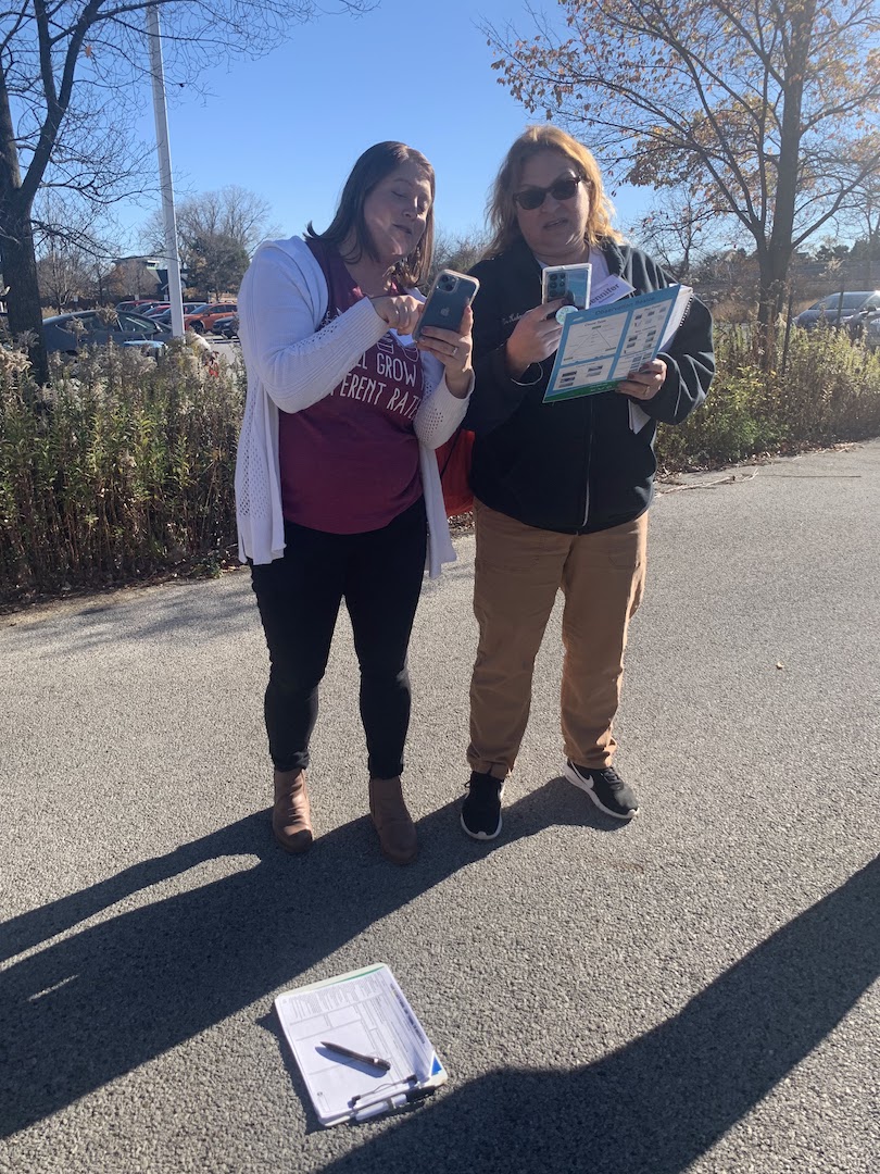 2 participants practice cloud protocols with the GLOBE Observer app on their phones and a printed cloud chart