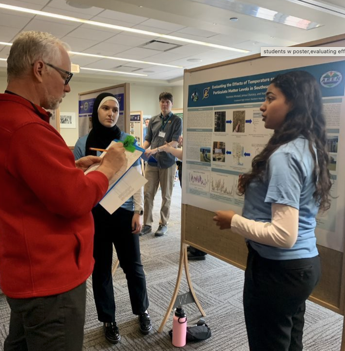 SRS students discuss their research with a scientist