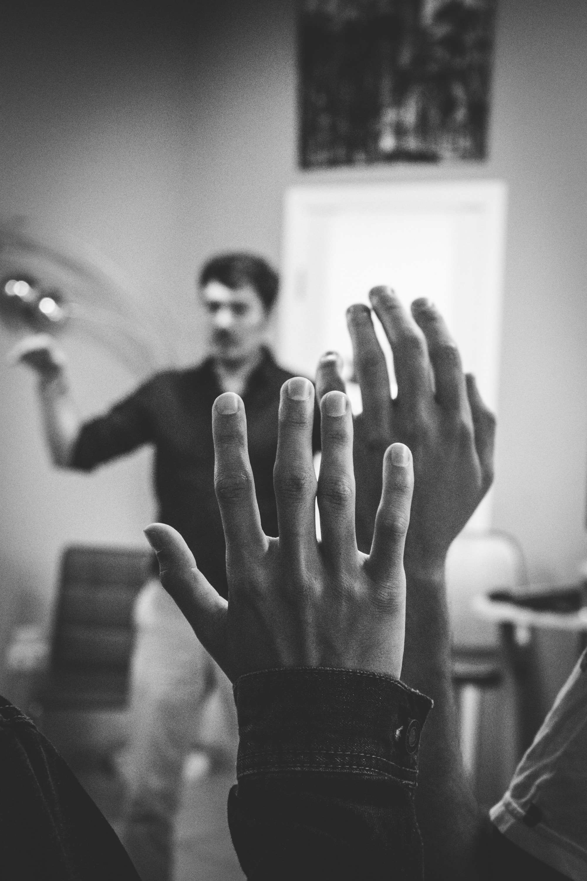 Hands raised in a classroom. Photo by Artem Maltsev