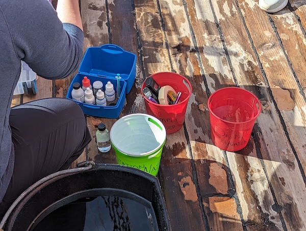 buckets and water quality measurement materials on the deck of a tall ship