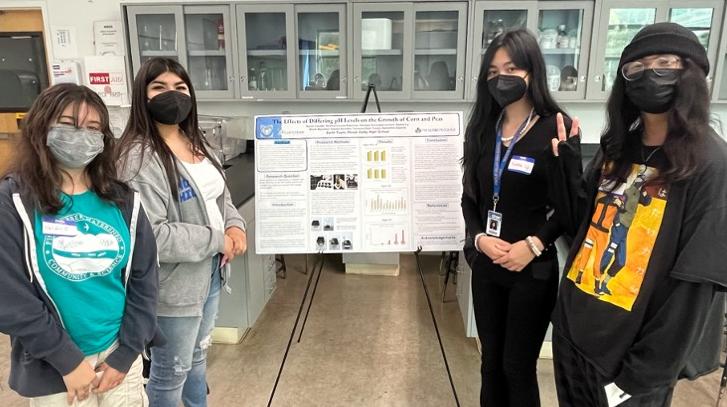 students stand with their research poster at the Chabot Space and Science Center student research symposium