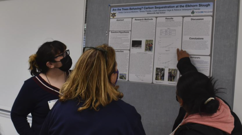 Two students present research to a reviewer at the 2022 Elkhorn Slough SRS.