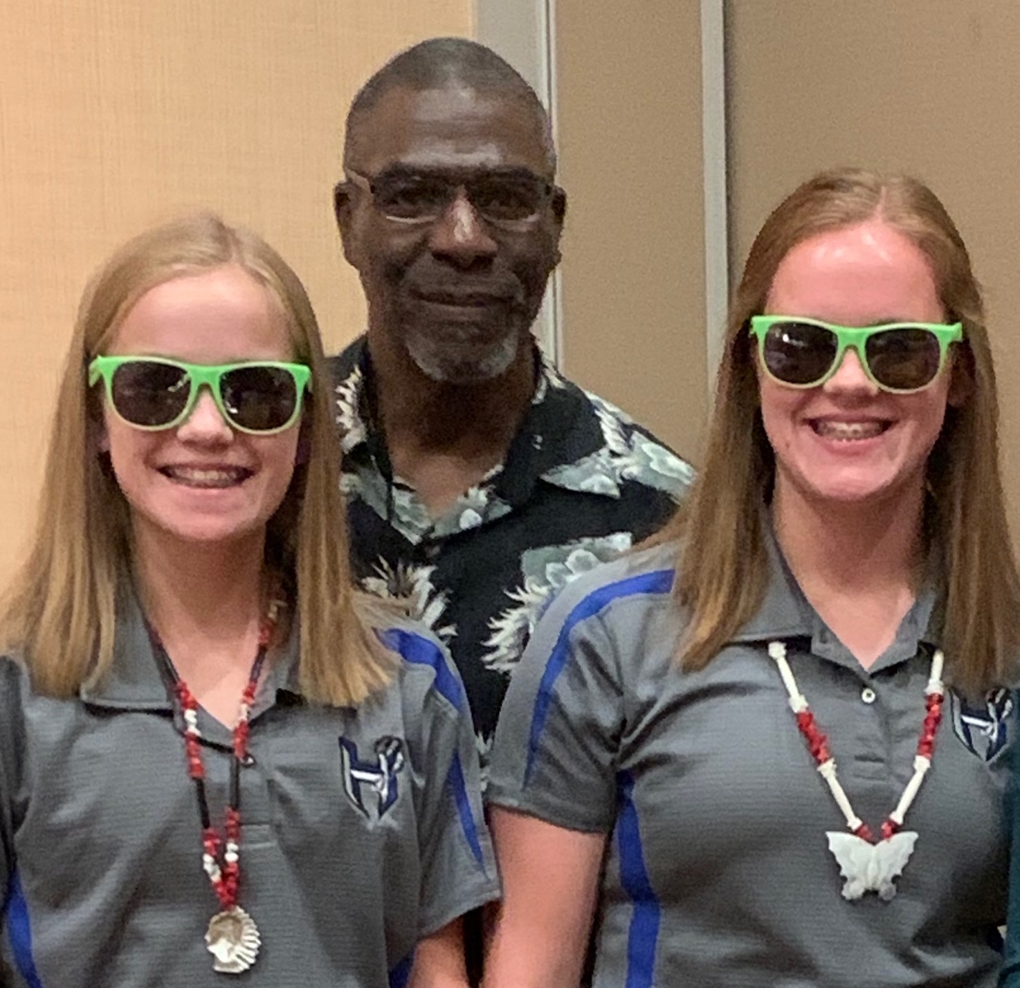 Nate Raynor with two students in lime green sunglasses - the peer choice recognition.