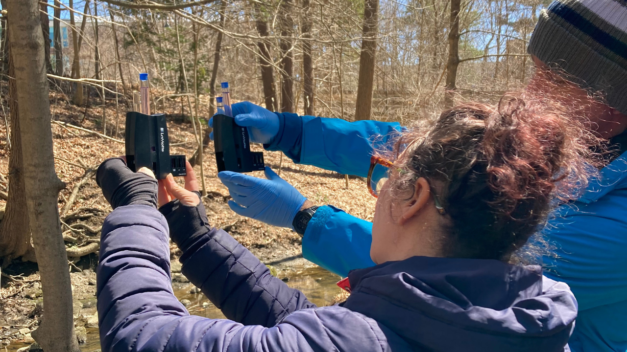 two adults hold nitrates kits to compare colors