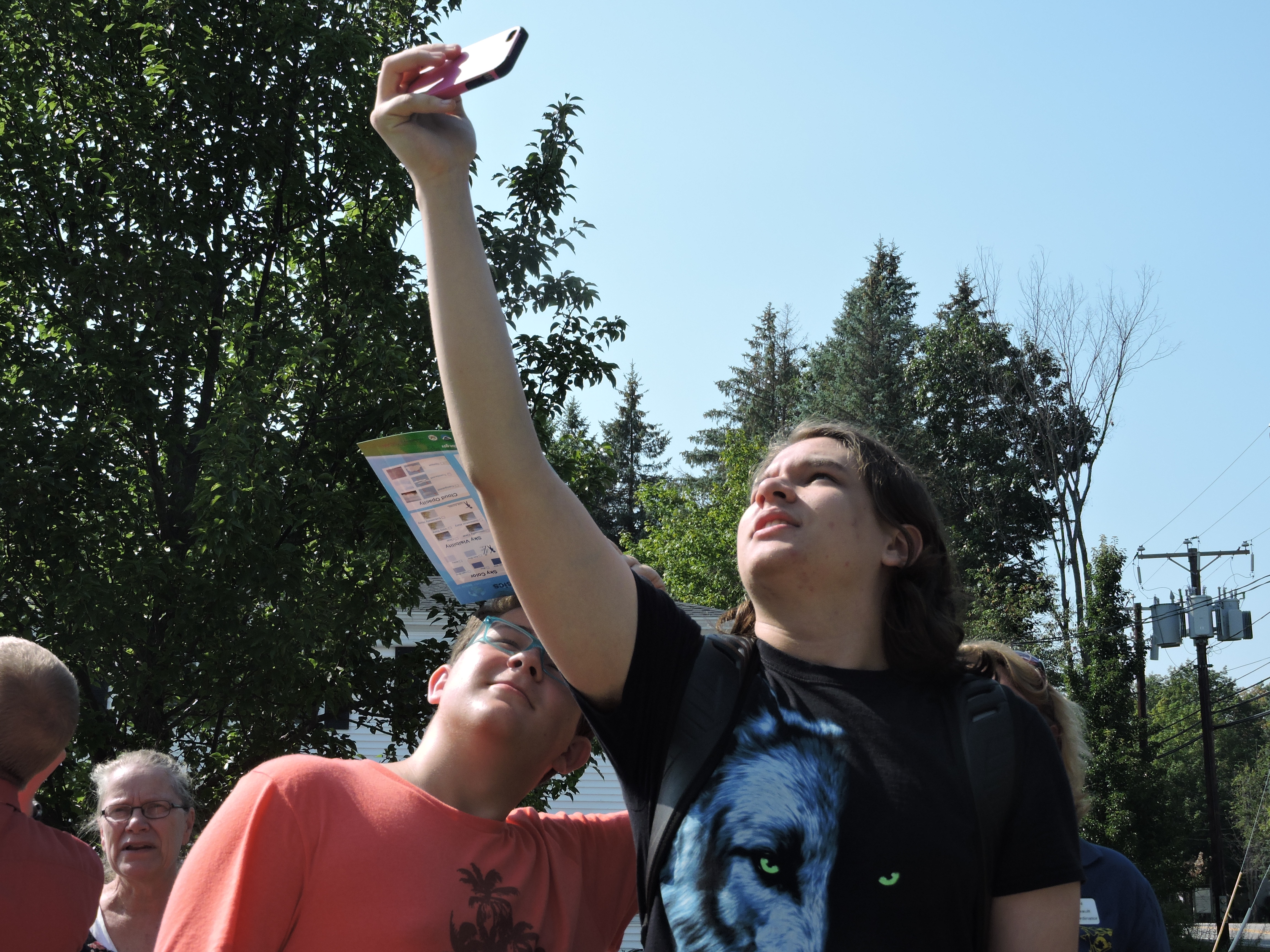two young male students using the observer app to take pictures of the sky and clouds