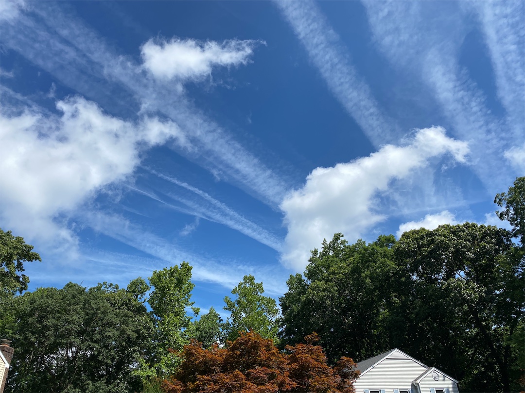 Image showing many contrails and a few cumulus clouds. 