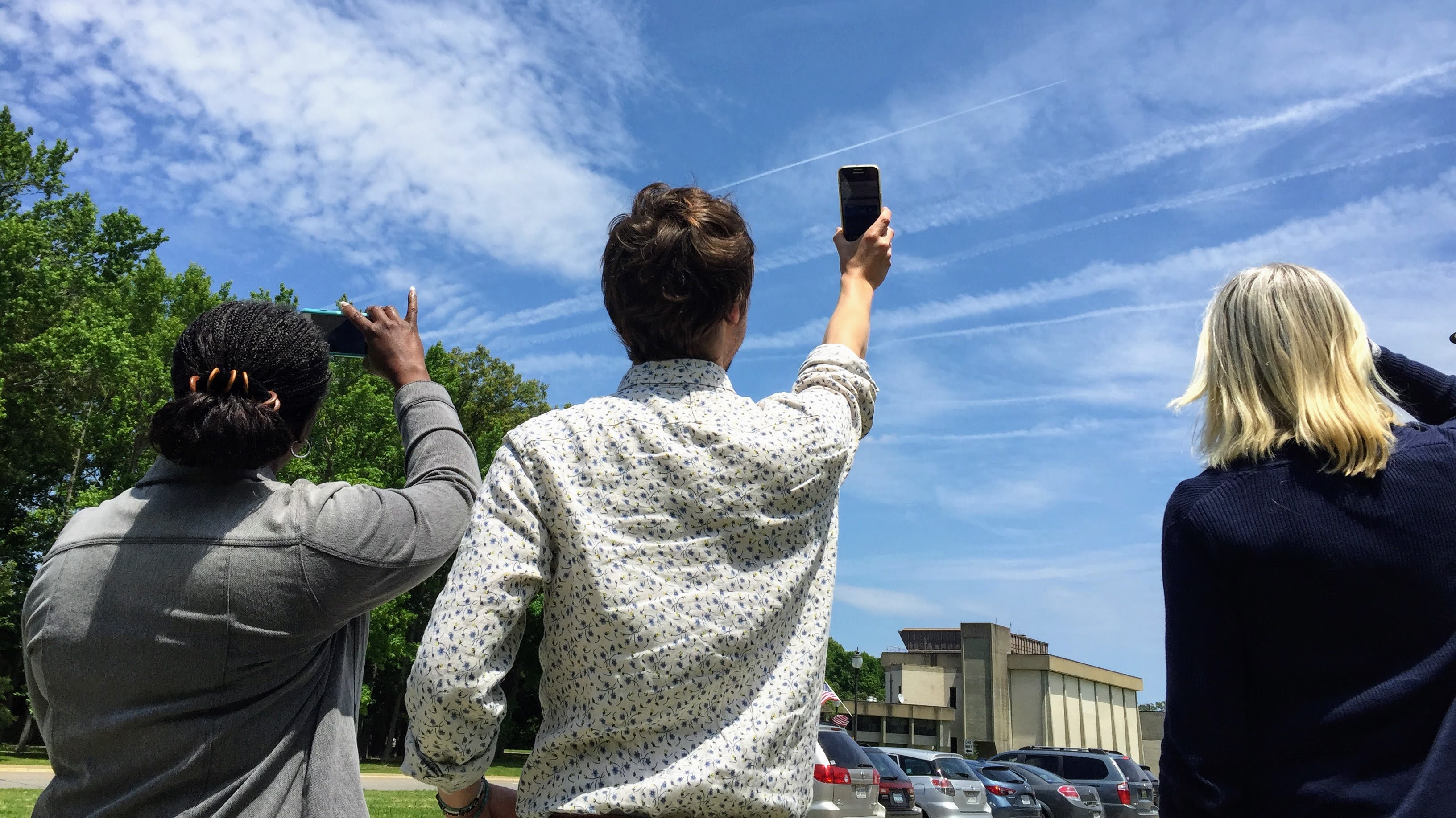 People looking at clouds and contrails in the sky and using the The GLOBE Program's GLOBE Observer app. Image source: NASA