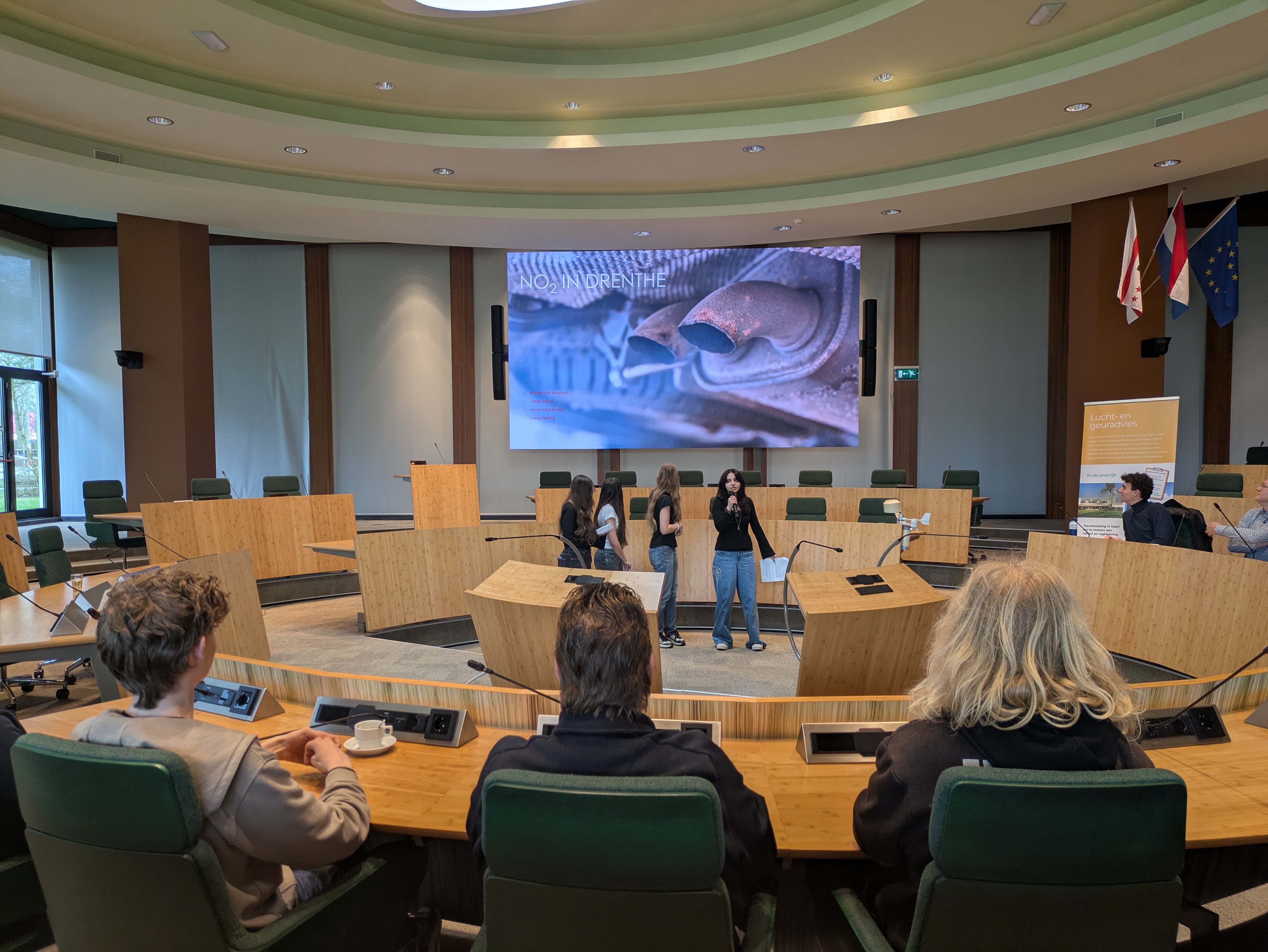 Students presenting in council chamber.
