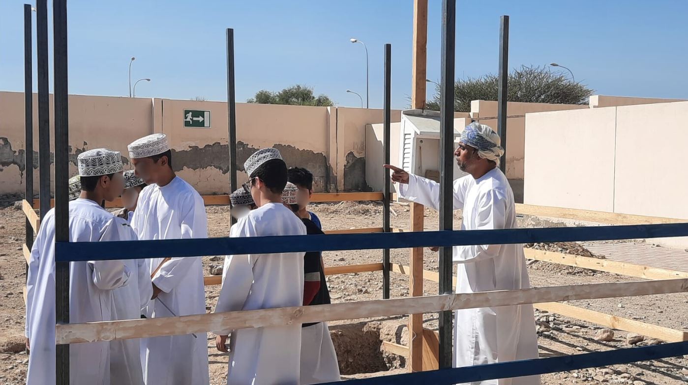 Educator speaking with students outside.