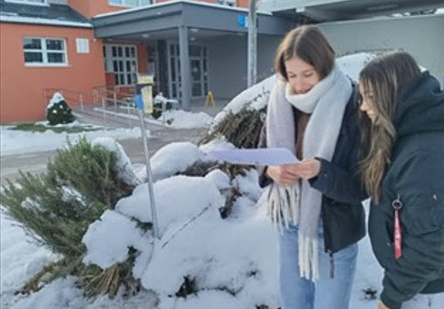 Students taking measurements in the snow.