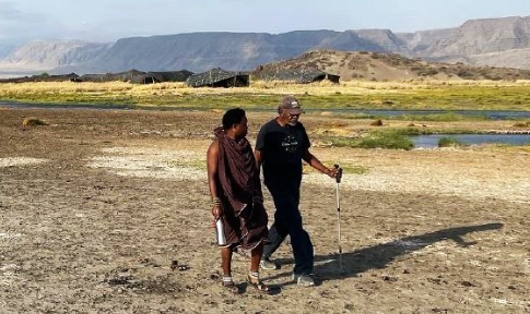 Dr. Francis walking with a friend across the African desert