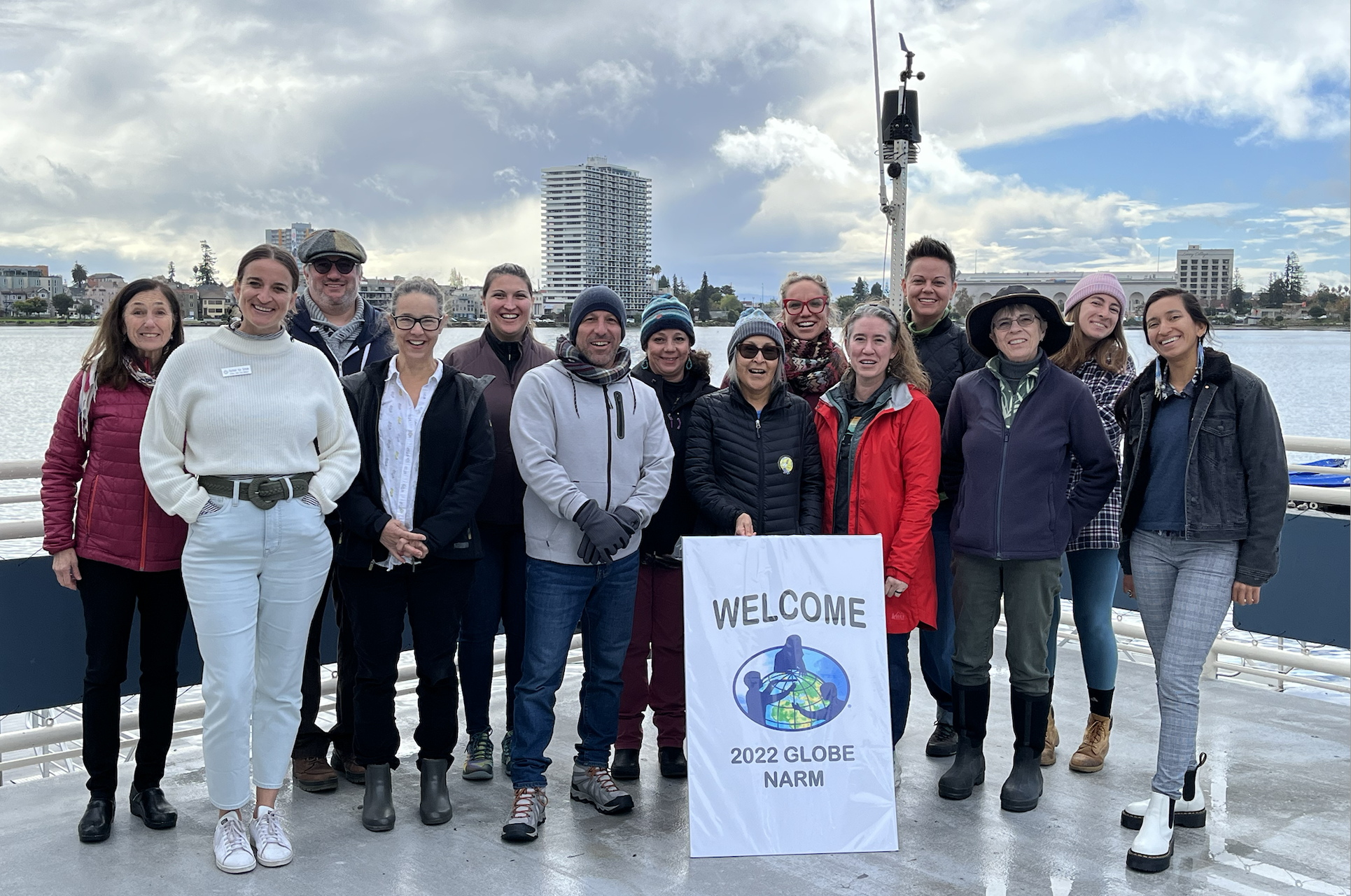 Participants at Oakland, CA, in-person NARM stand on a dock in front of Lake Merritt