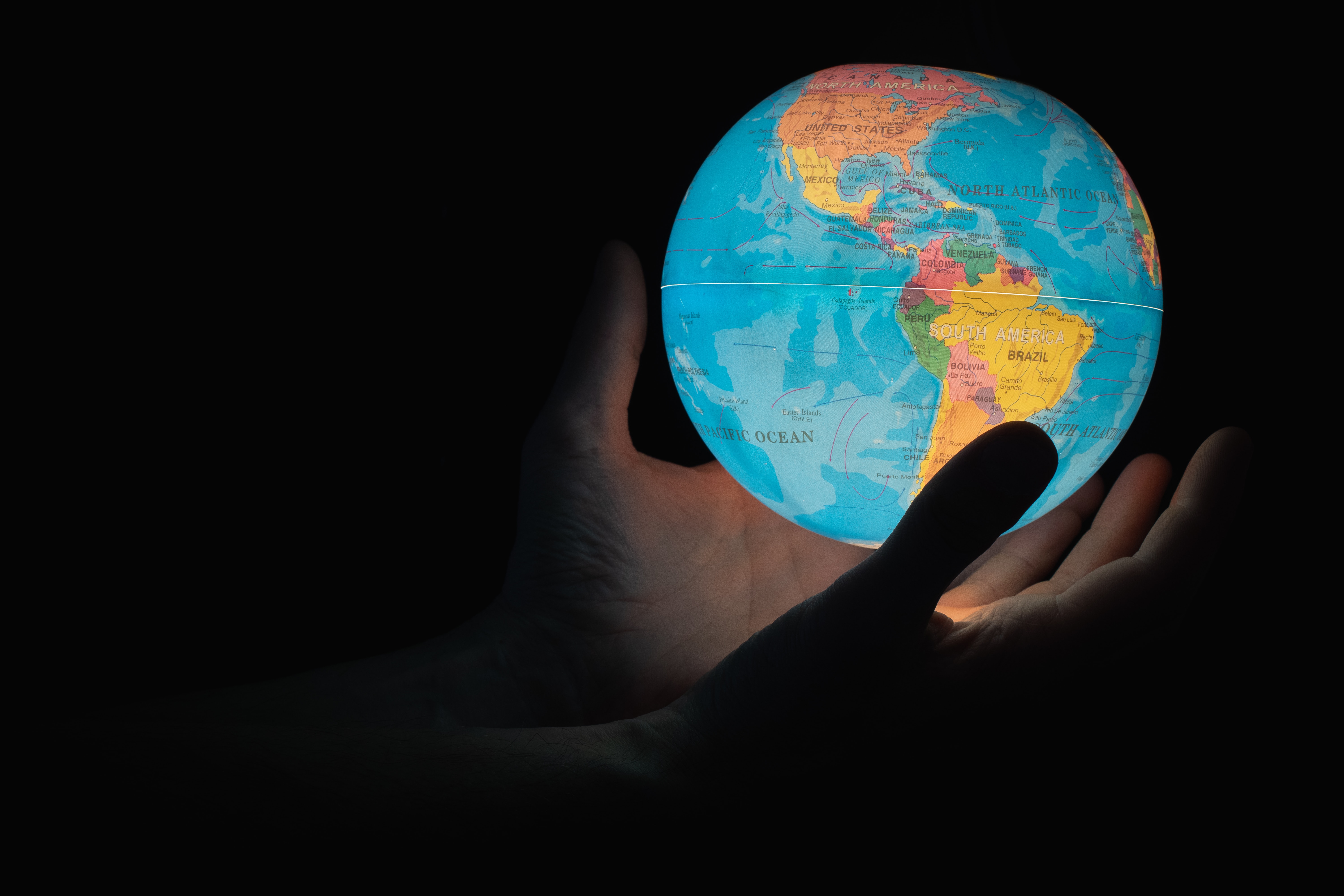 Image of person holding a globe by Greg Rosenke