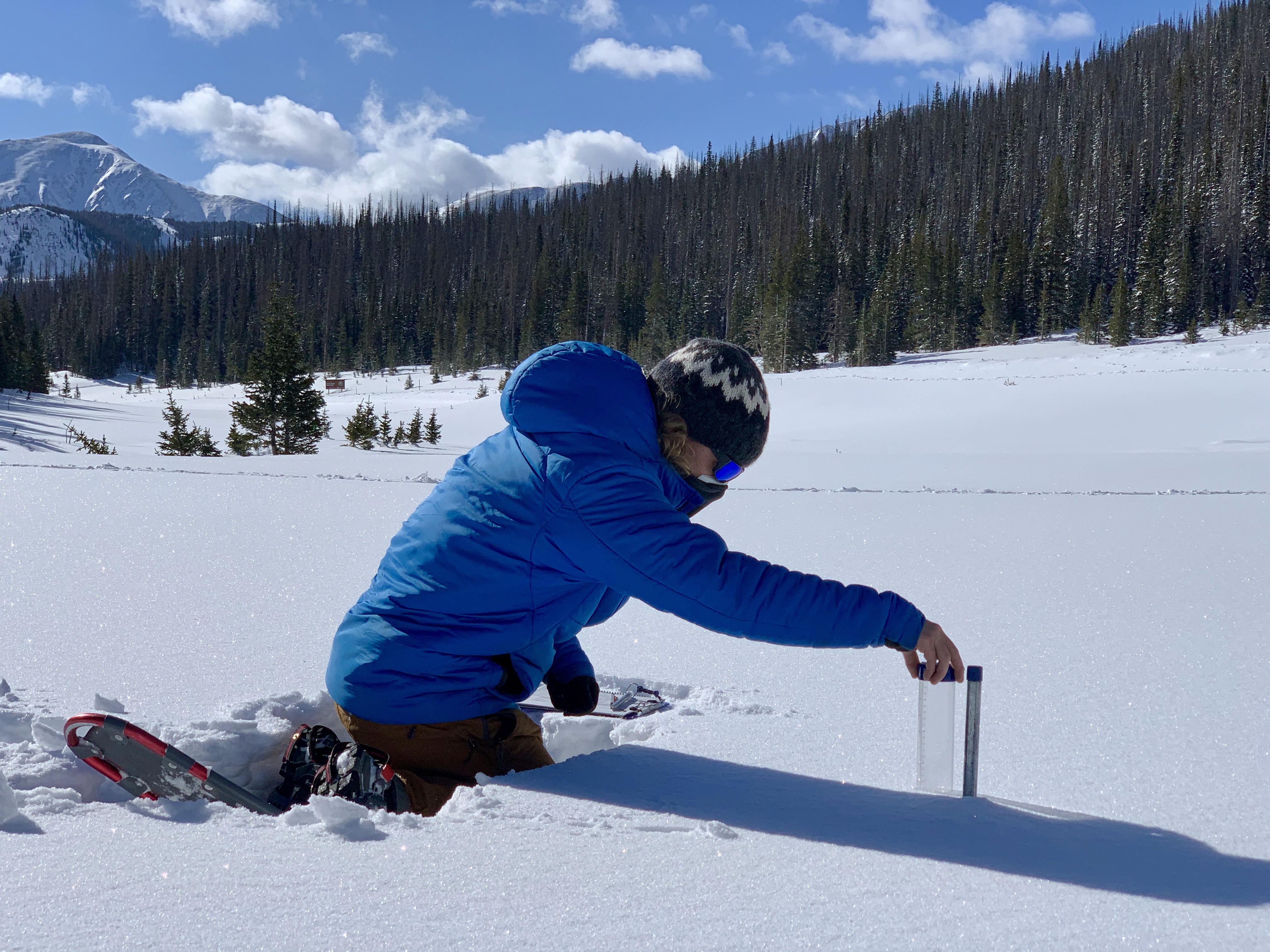   Image of person taking snowpack measurement. Credit: NASA