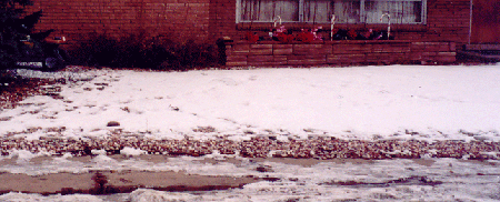 Snow on yard covered with gravel.  Snow depth 1-2 cm