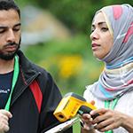 Two people using a scientific instrument outside.