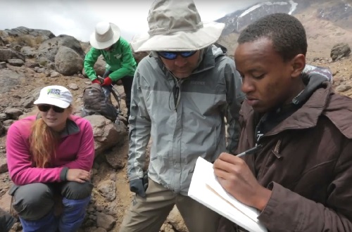 A student discusses notes with a teacher outdoors