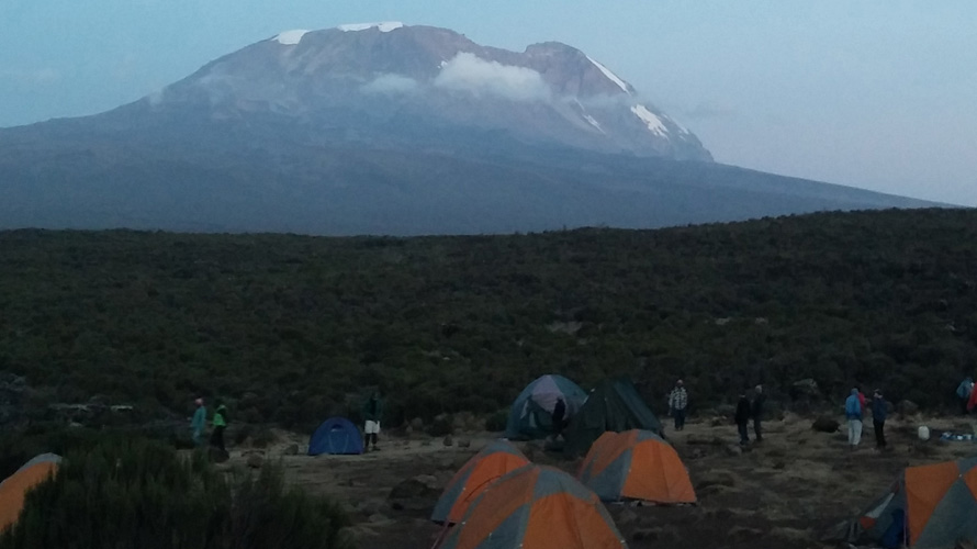 Tents in the foreground with a mountain in the background.