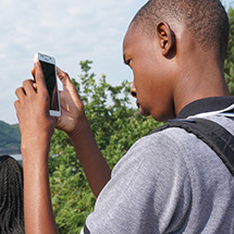 A boy uses his phone to snap a picture with his phone (shooting vertically).