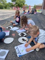 students outdoors observing soil