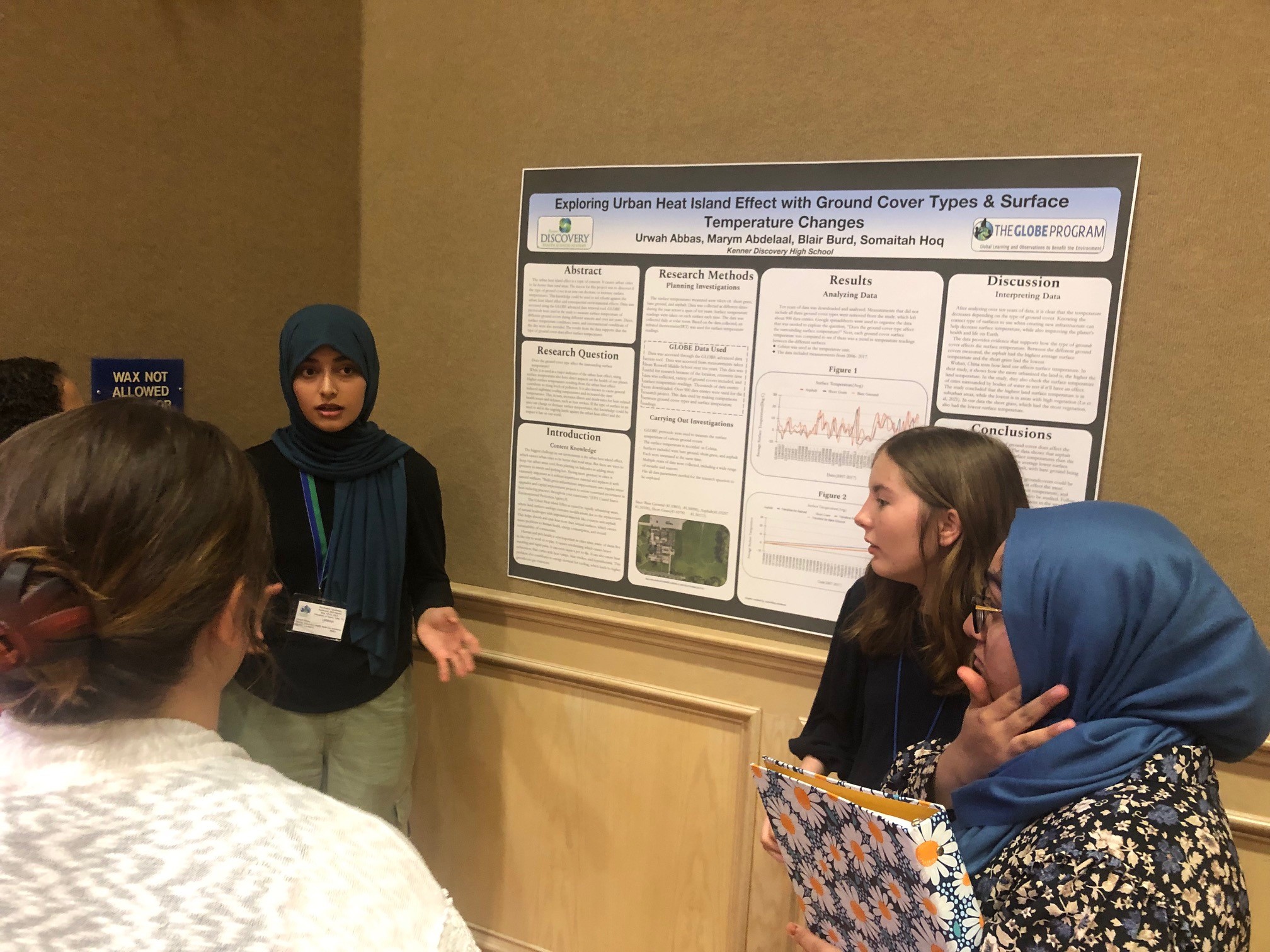 Three students present their research poster at the student research symposium