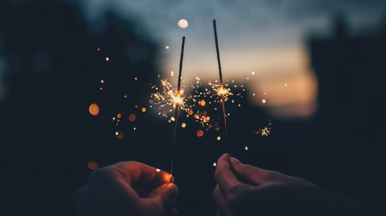 Two hands holding sparklers. Image from unsplash.com
